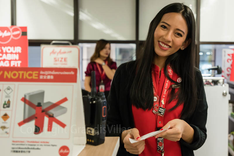 Красивая девушка, обслуживающая на стойке регистрации компании AirAsia