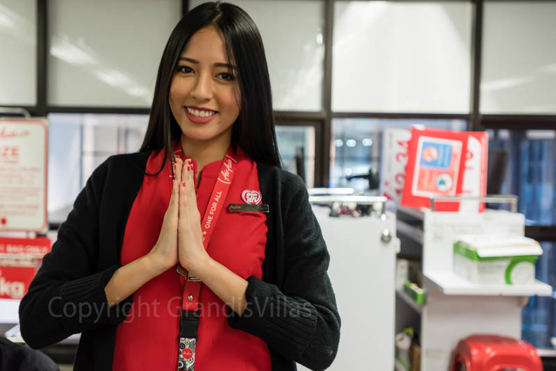 Красивая девушка, обслуживающая на стойке регистрации компании AirAsia